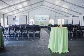 A tented reception set with tables, linens and lighting
