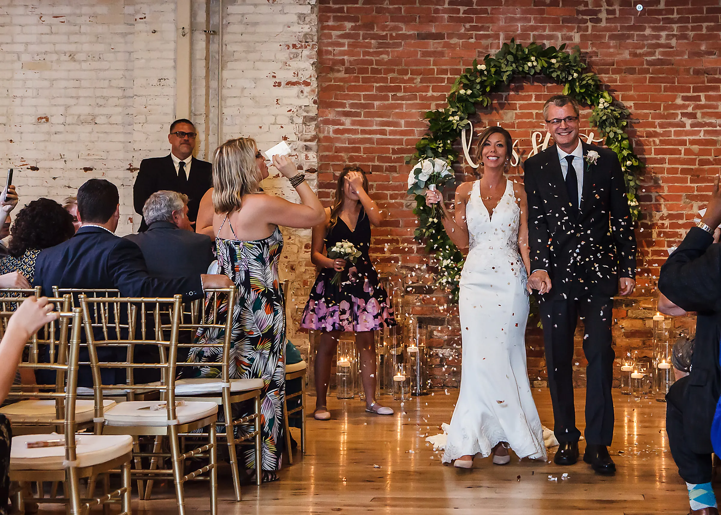 Newlyweds walking through a confetti send-off at a Kentucky wedding reception