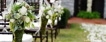 An outdoor wedding ceremony set with chairs and florals